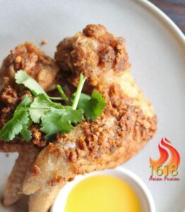 Crispy fried chicken wings with cilantro garnish.