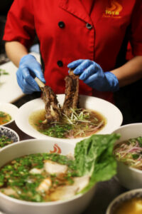 Chef preparing Vietnamese beef noodle soup, pho.
