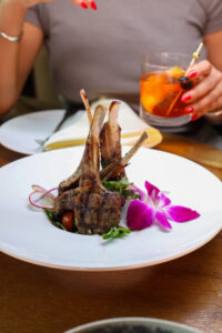 Grilled lamb chops with edible flower garnish.